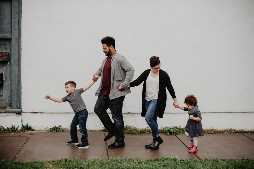 pexels-photo-2253879 A joyful family walking together outdoors, holding hands in a playful and happy moment.
