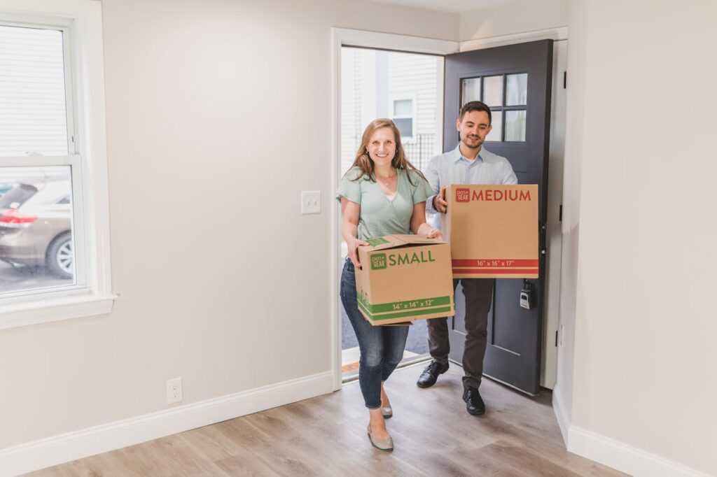 pexels-photo-8292837 A joyful couple carrying boxes into their new home, symbolizing a fresh start.